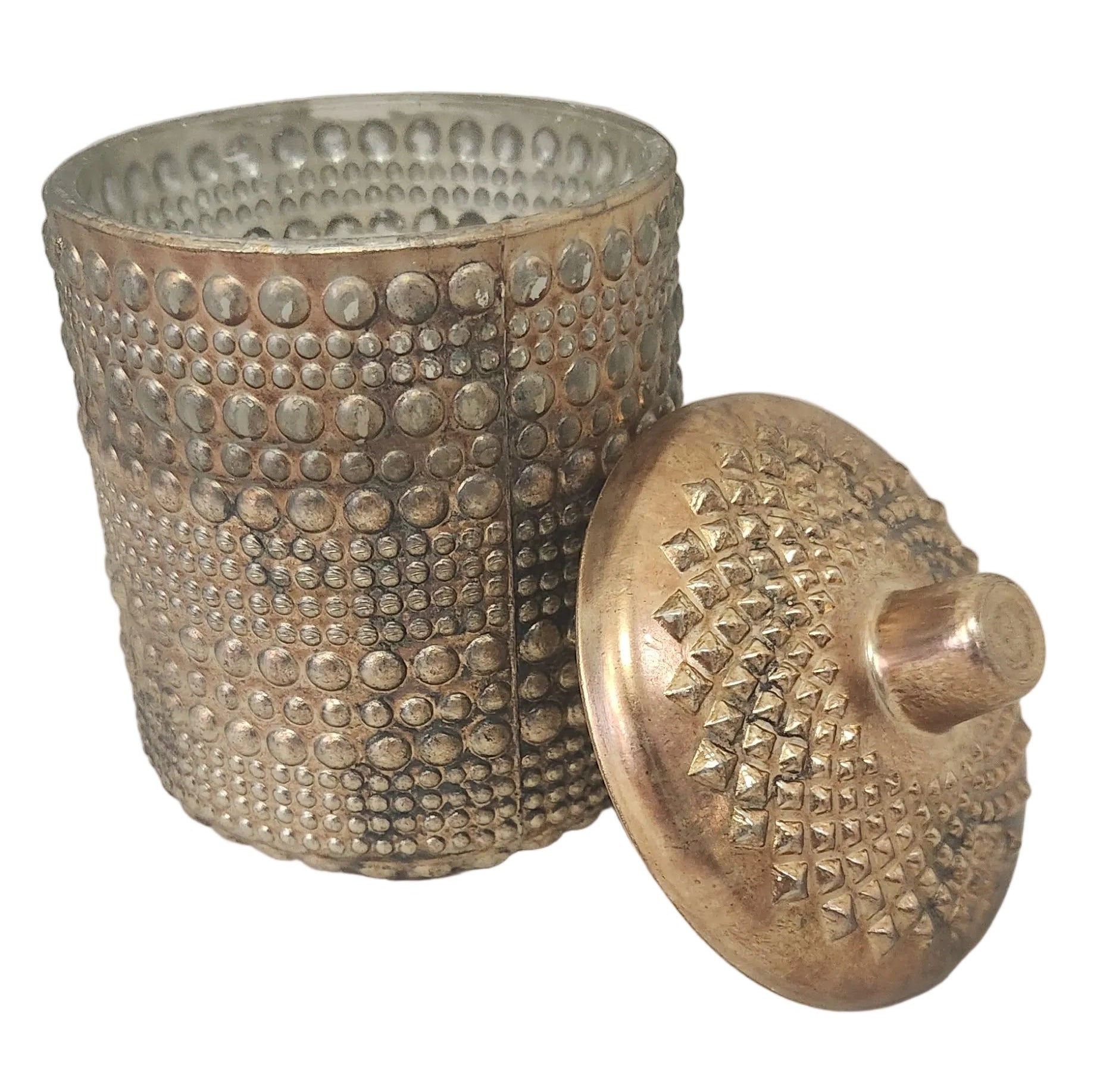 Decorative metal container with textured surface and lid on a light gray background