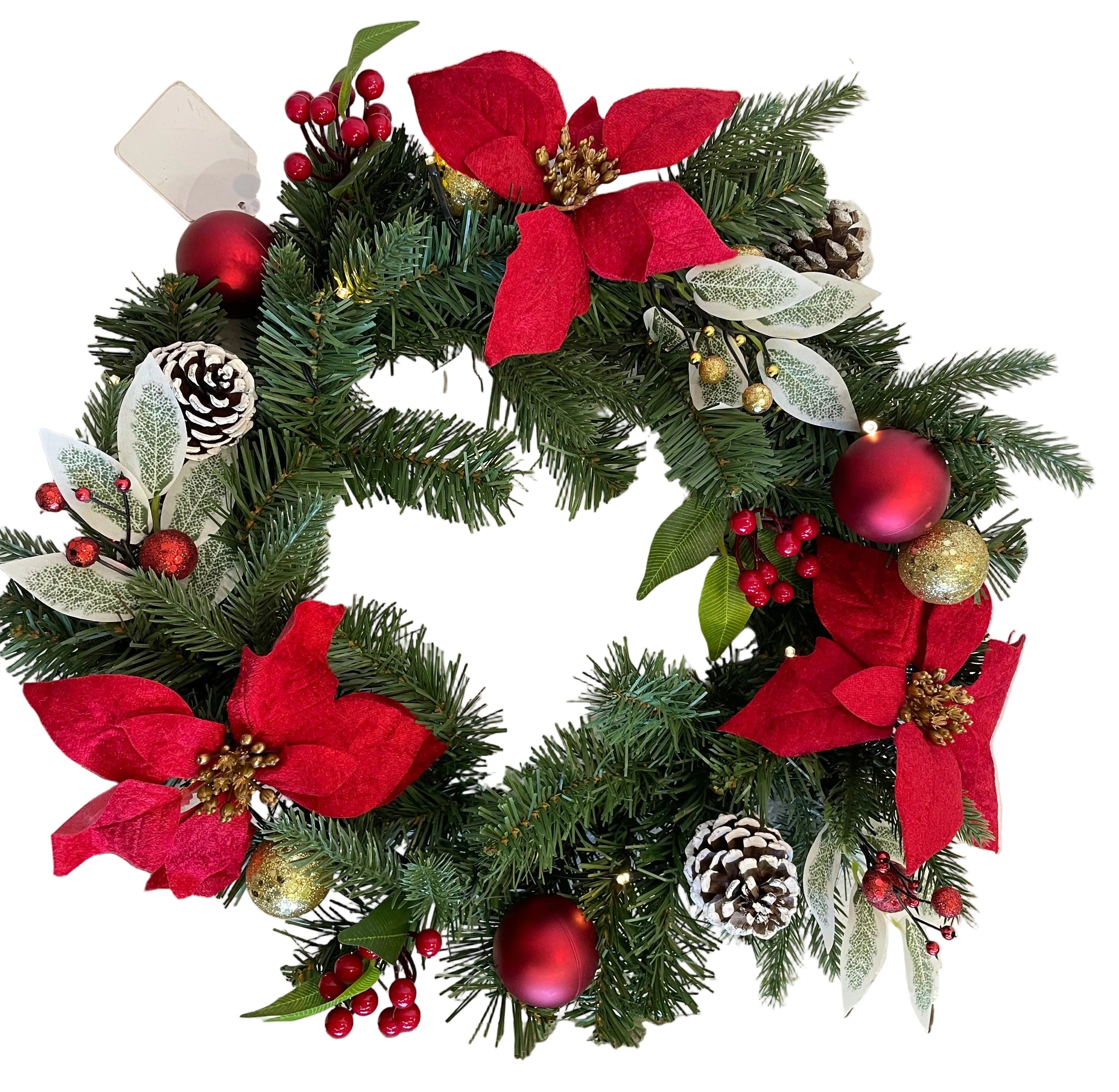 A festive Christmas wreath decorated with green pine branches, red poinsettias, red berries, white frosted leaves, pinecones, and red and gold ornaments.