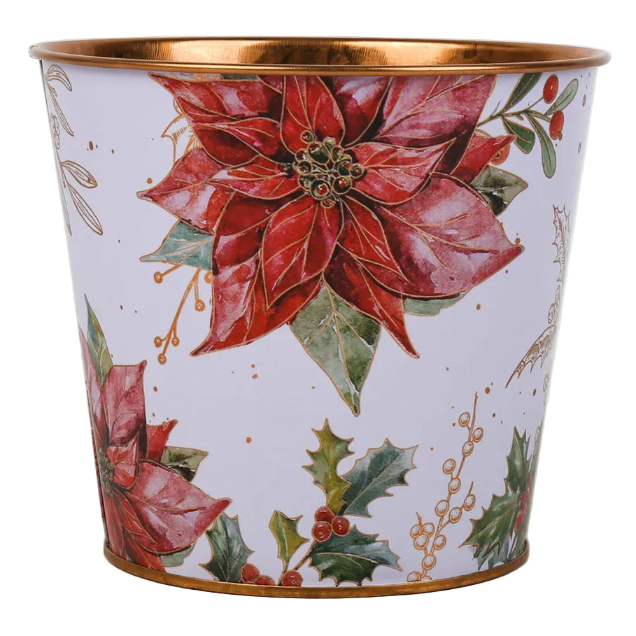 A cylindrical metal pot planter with a white background decorated with red poinsettias, green holly leaves, and gold-toned trim at the rim and base.