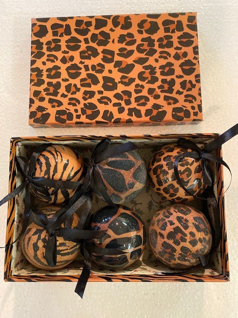 A box of ornamental balls designed with a leopard print pattern, displayed in front of an orange and black patterned box.