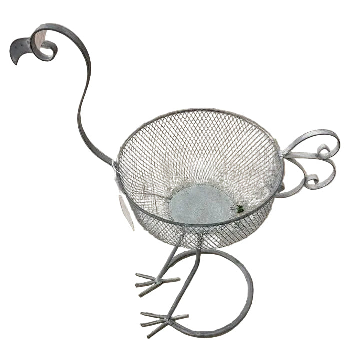 A silver metal bird-shaped bird feeder pot with a long leg, standing on a wooden floor.