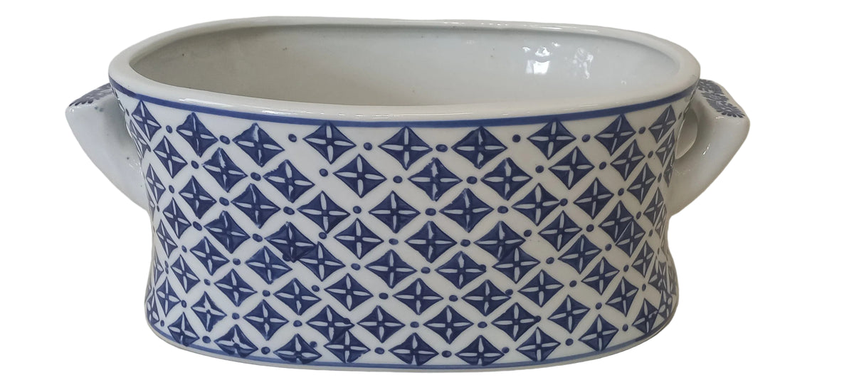 A white and blue patterned oval bowl with a handle.