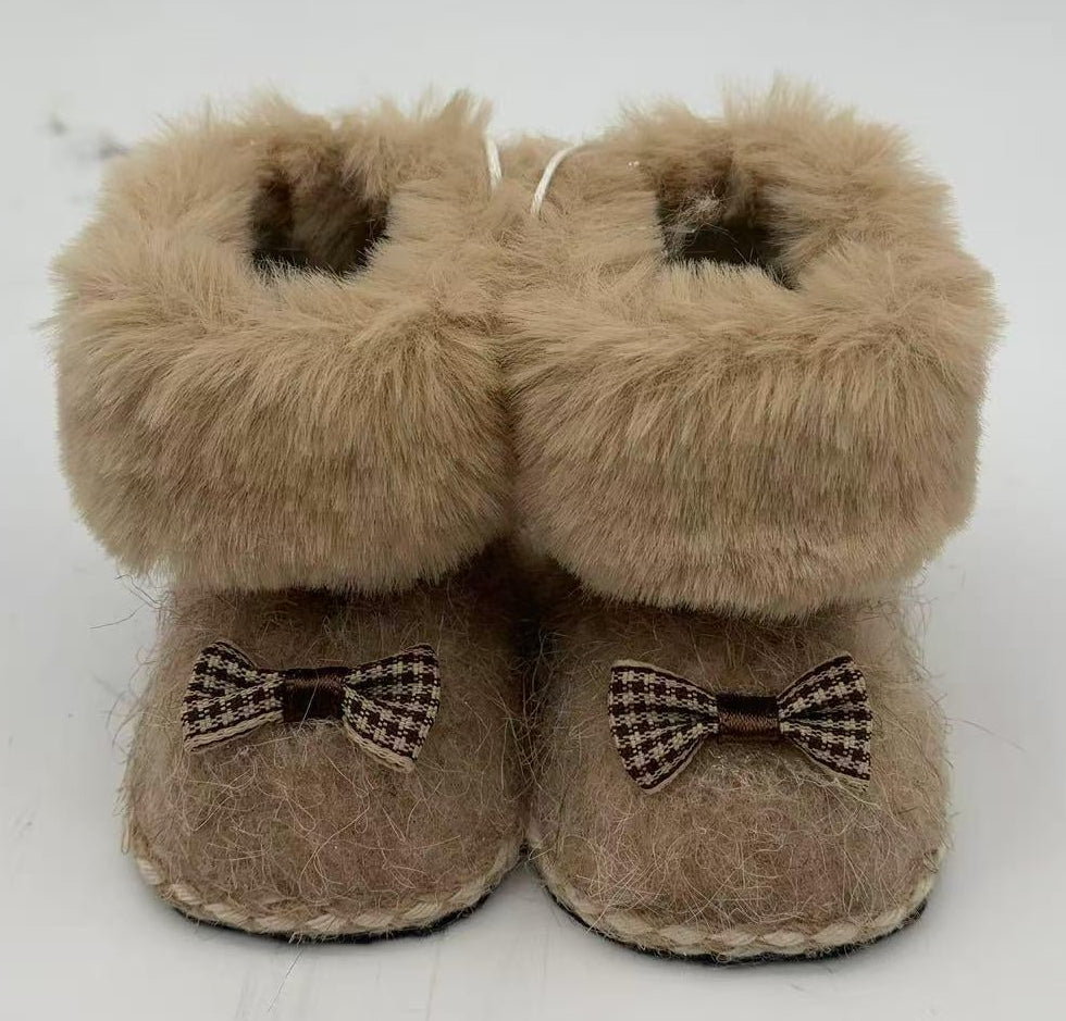 A pair of beige faux fur booties with small brown and white gingham bow details on the front.