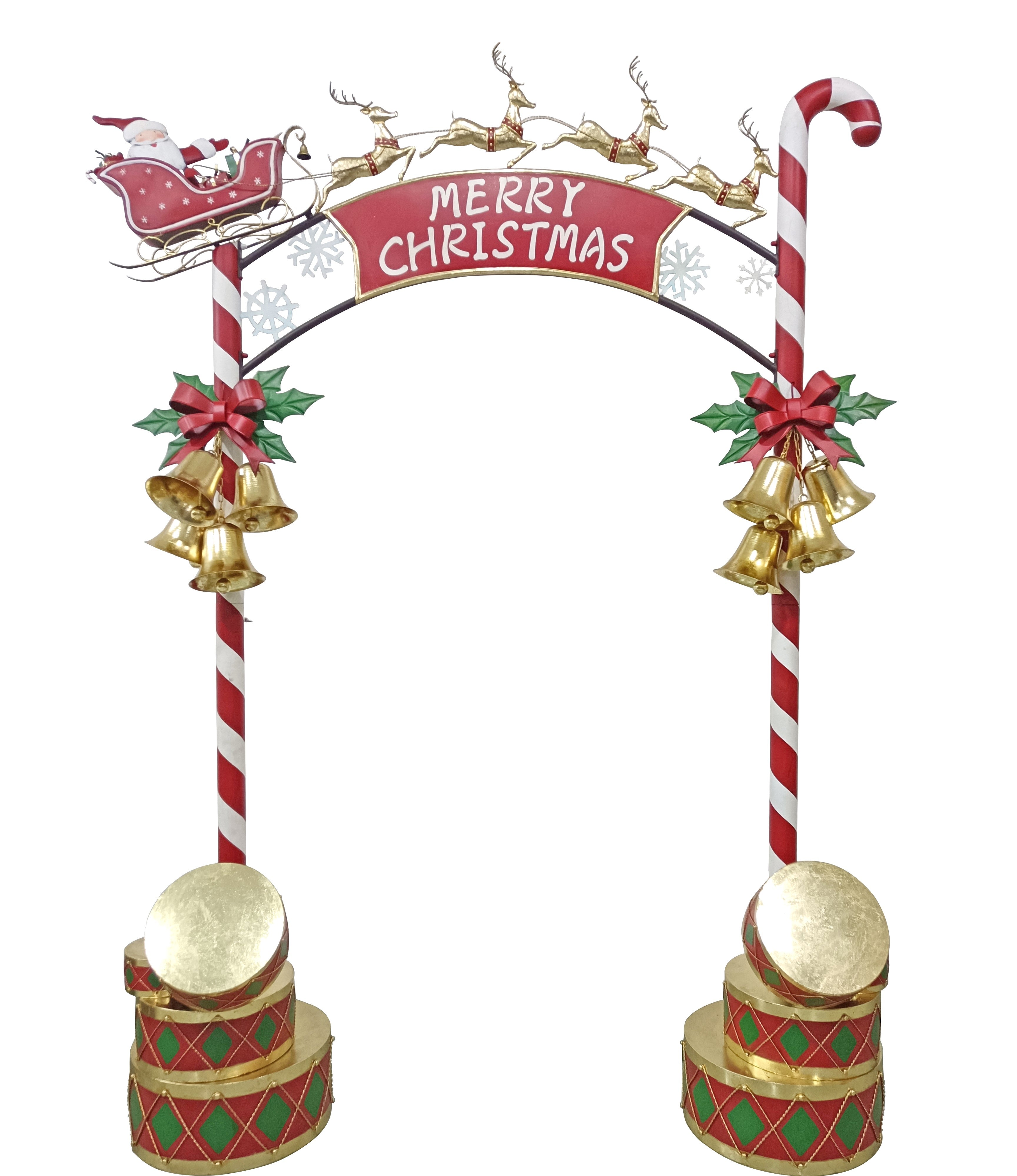 A festive Christmas arch decoration with a red arched top reading 'MERRY CHRISTMAS,' reindeer along the top, candy cane posts with red-and-white stripes, gold bells, green holly leaves, red bows, and stacked gold and red-and-green drums 