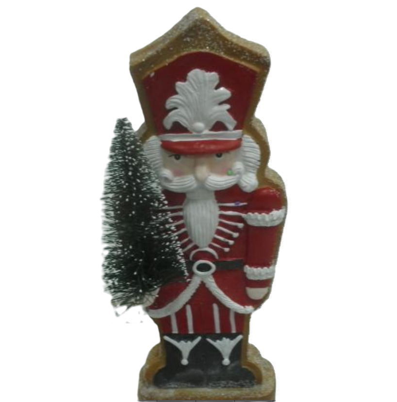 A gingerbread-shaped holiday ornament in red with a white hat, holding a Christmas tree, and decorated with icing 'clothes' and a black decorative element.