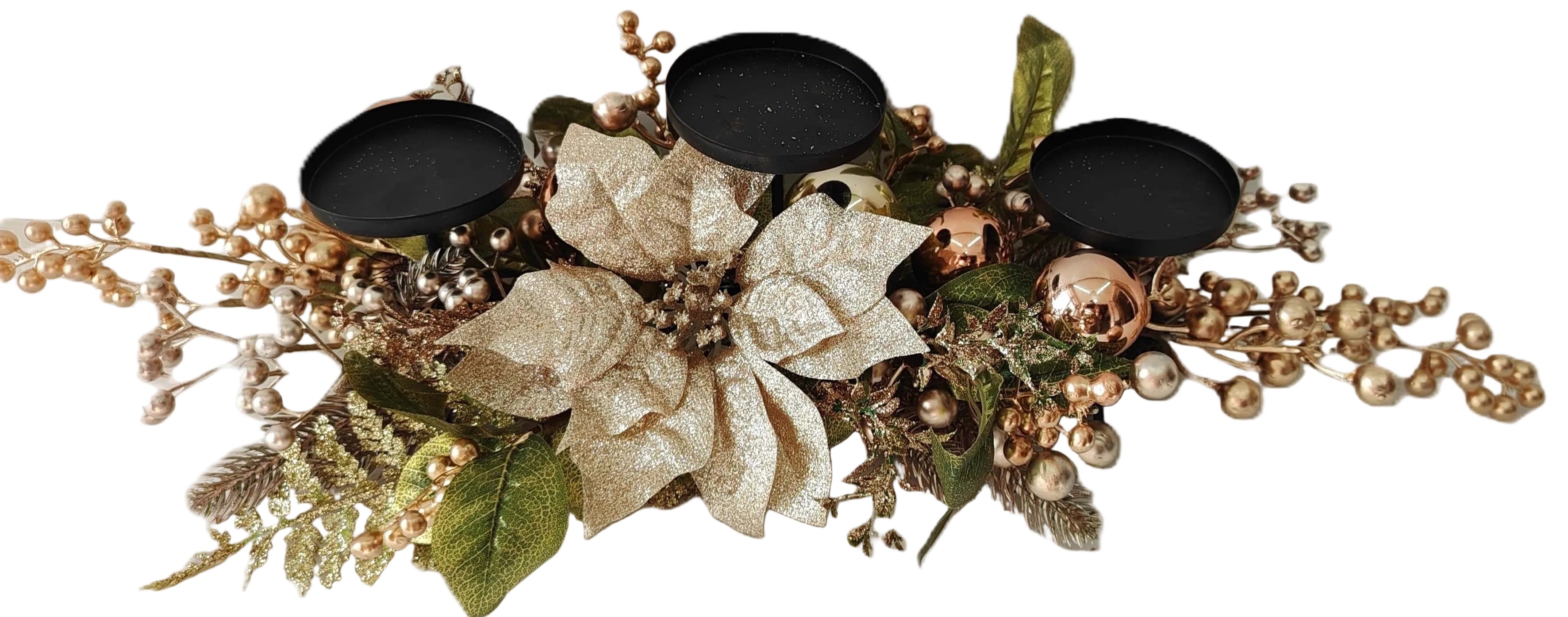 A holiday decorative centerpiece with a large gold glitter poinsettia, green leaves, gold berries, pinecones, and three black metal candle holders.