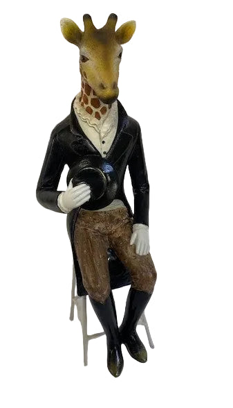 A figurine of a giraffe wearing a tall chair, complete with a black coat, white shirt, and a top hat. It is seated on a small chair.