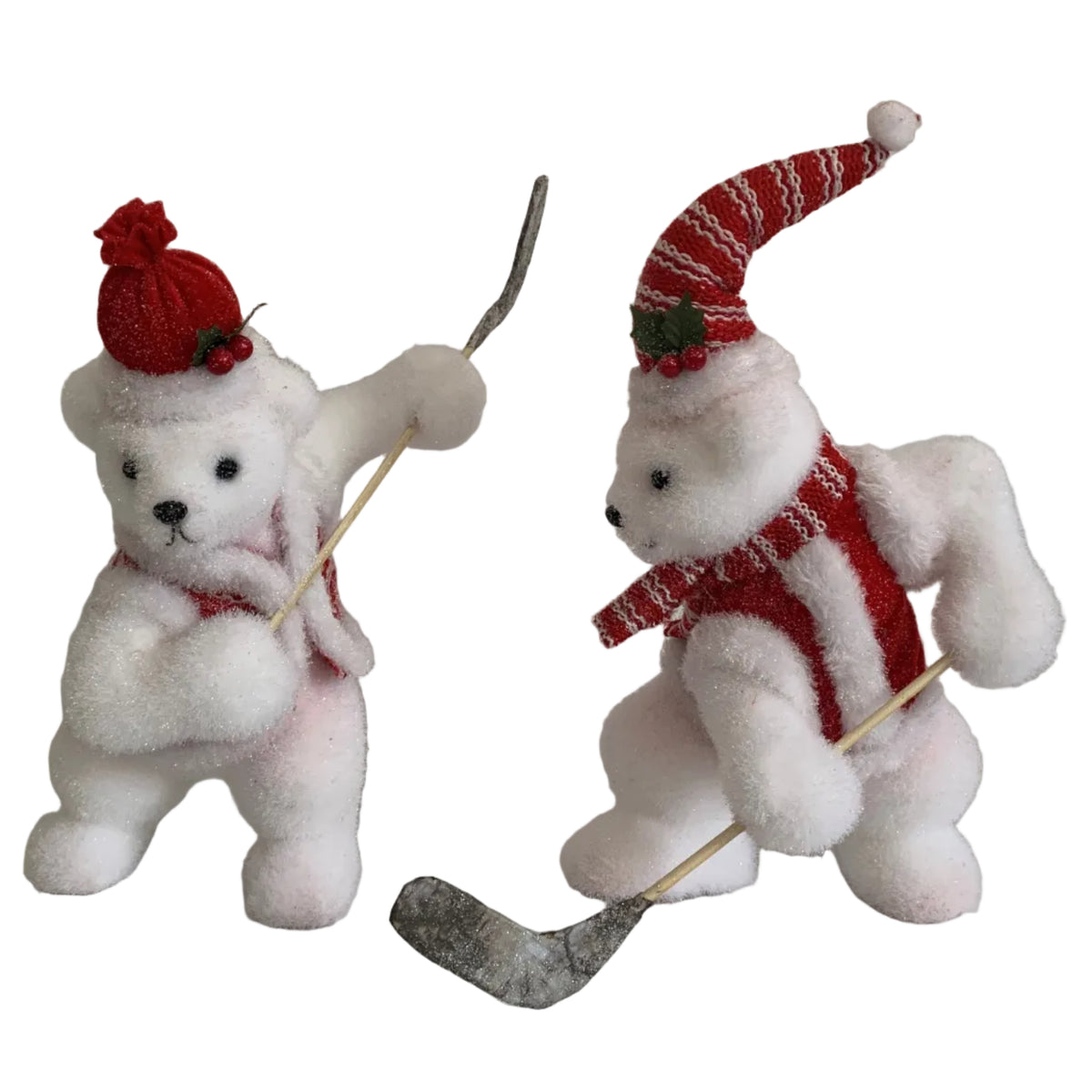 Two white teddy bear figurines dressed in red and white hockey attire, holding hockey sticks.